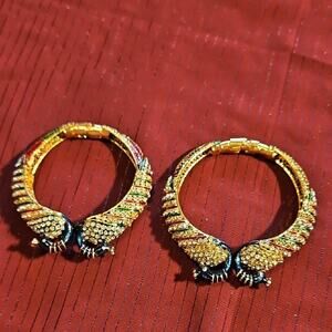 A Pair of Gold and Green Ornate Bracelets with Intricate Textures